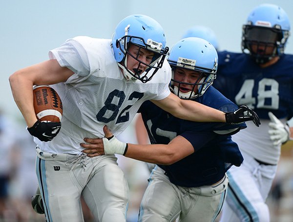 Zach Vaughn, left, Springdale Har-Ber tight end, is wrapped up by safety Katen Pullen after a first down catch Thursday during the Wildcats’ spring game in Springdale. 