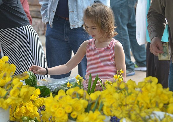 Quincy Schaffer, 7 of Fayetteville, takes a look at the fresh flowers in April at the Fayetteville Farmers Market on the city square. 