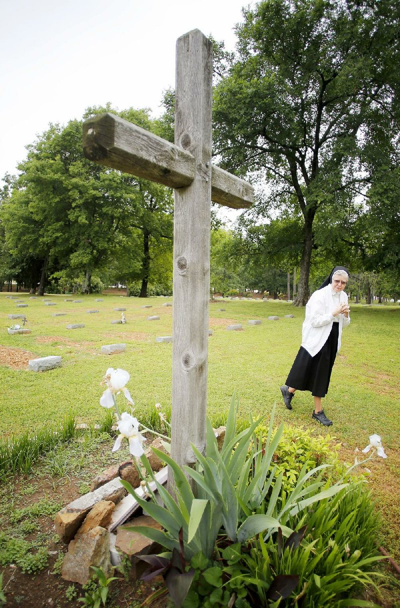 Sister Dolores Vincent Bauer visits the graves of sisters Frances Anne Braddock, Gabriel Brandt and Irma Twenter in the St. Scholastica Monastery cemetery. The three nuns died in early April. 