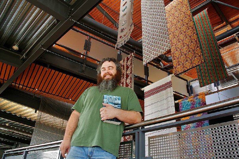 Fantasy author Patrick Rothfuss (The Kingkiller Chronicles) finds a royal spectacle amid the tapestries that hang inside Heifer International headquarters in Little Rock. Rothfuss supports Heifer’s charity work through book sales. Fantasy readers naturally relate to the same things that Heifer advocates, he says: “The goat, the honeybee, trees, preventing soil erosion.” 
