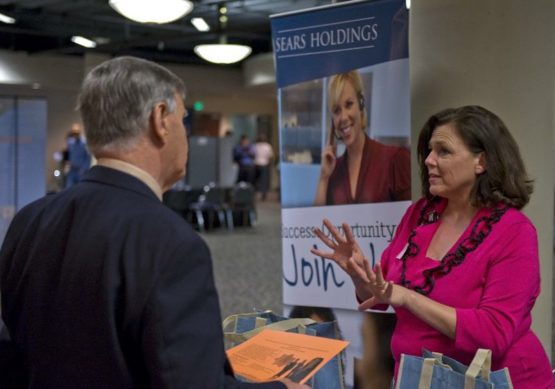 Sears Holdings Corp. representative Joanna Van Brandt (right) speaks with a job seeker at a job fair at San Antonio in March. The company posted a $279 million first-quarter loss on Thursday. 