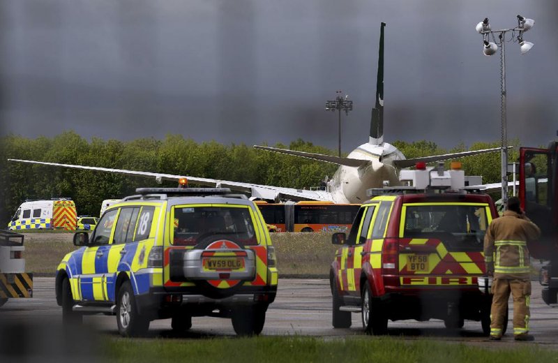 Police and rescue service workers watch Friday at Stansted Airport, Essex, England, after a flight bound for Manchester from Lahore, Pakistan, was diverted to Stansted after two men on board threatened to blow the plane up. The two passengers were arrested on suspicion of endangering the aircraft. 
