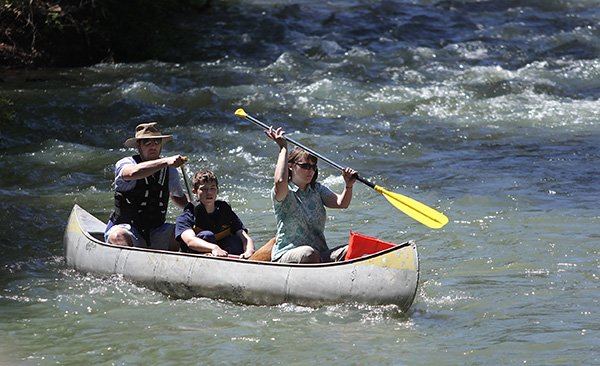 Paul, Shad and Sarah Gibson, all of Carbondale, Ill., make their way into the Buffalo National River from the low water bridge at Ponca. The river is at its highest levels after several years of drought condition. 