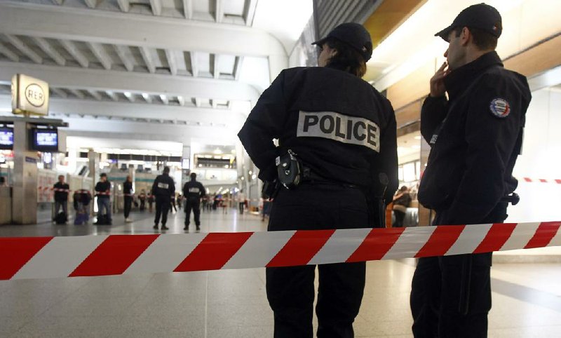 Police officers stand near the cordoned off spot where a French soldier was stabbed in the throat in the busy commercial district of La Defense, outside Paris, Saturday May 25, 2013, and France's president said authorities are investigating any possible links with the recent slaying of a British soldier.(AP Photo/Remy de la Mauviniere)