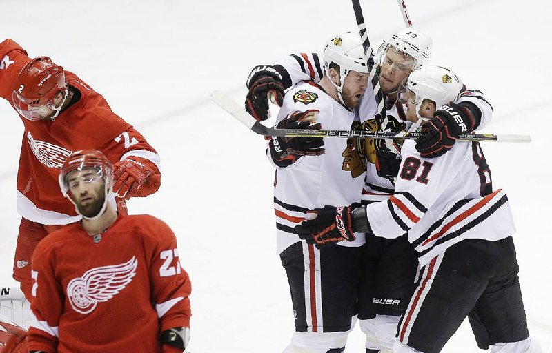 Chicago Blackhawks left wing Bryan Bickell (29), left wing Daniel Carcillo (13) and right wing Marian Hossa (81) of the Czech Republic, celebrate Bickell's goal next to Detroit Red Wings defensemen Kyle Quincey (27) and Brendan Smith (2) during the third period of Game 6 of the NHL hockey Stanley Cup playoffs Western Conference semifinals in Detroit, Monday, May 27, 2013. (AP Photo/Carlos Osorio)