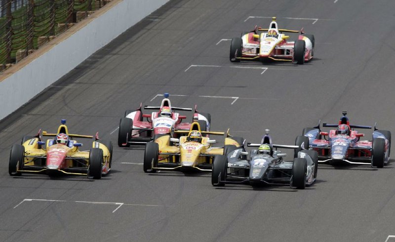 Tony Kanaan (second from right) takes the lead from Ryan Hunter-Reay (1) on a restart on the 197th lap, holding on to win the 97th Indianapolis 500 under caution Sunday at the Indianapolis Motor Speedway. Rookie driver Carlos Munoz (left), finished second, Hunter-Reay was third and Marco Andretti (right) finished fourth. 
