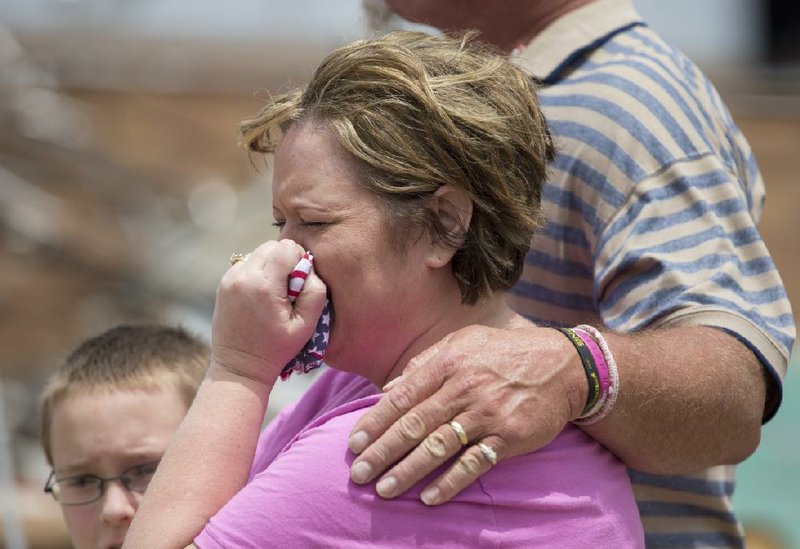 Julie Lewis gives way to tears near the destroyed Plaza Towers Elementary School with her son, Zack, and husband, Scott Lewis, after talking with President Barack Obama on Sunday in Moore, Okla. 