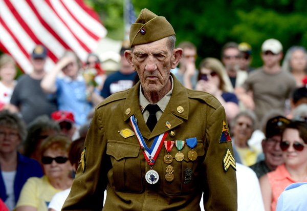 Eugene Keister walks up to the podium before reading a poem he wrote, “Just a Common Soldier,” during the Memorial Day ceremony Monday at the Fayetteville National Cemetery. 