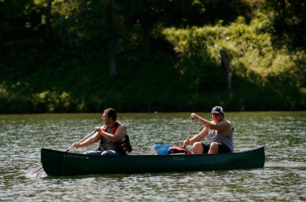 Brandon Beasley, left, and Austin Church, both of Cave Springs, paddle their canoe Friday across Lake Atalanta in Rogers while fishing.