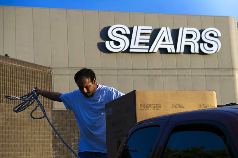 A customer secures a new washing machine purchased at a Sears Holdings Corp. store in the back of a pickup truck in Richmond, California, U.S., on Tuesday, Feb. 26, 2013.  Photographer: David Paul Morris/Bloomberg