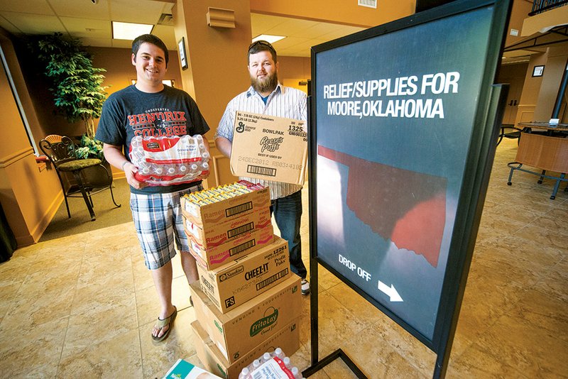 Nathan Brewer, left, who grew up in Moore, Okla., and Nick Jacobsen help collect donations at Antioch Baptist Church in Conway to take Saturday to victims of the EF5 tornado that hit Moore. Items may be dropped off through Friday at Antioch, 150 Amity Road, where Brewer is the high-school-student pastor. Brewer’s father is pastor of Southgate Baptist Church in Moore, which is serving as a central collection site for tornado-victim donations.