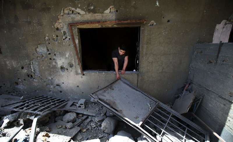A Lebanese man cleans up around his home Wednesday in the village of Hermel, after it was hit by what villagers said were Syrian rebel rockets. Shells from Syria regularly hit the area in northeastern Lebanon, a predominantly Shiite region. 