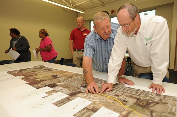 Fayetteville Mayor Lioneld Jordan, right, and resident Robert Page use a map Thursday to discuss a series of proposed improvements and extensions to Rupple Road during a public forum and information gathering session at the Boys & Girls Club of Fayetteville. 