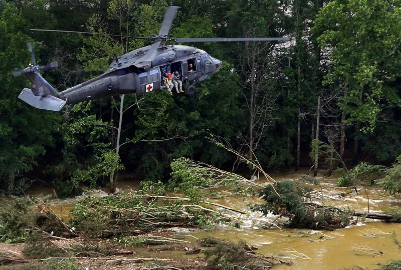 National Guard rescue team members scout over the Fourche LaFave River in Y City on Friday morning, searching for missing Arkansas Game and Fish officer Joel Campora. 