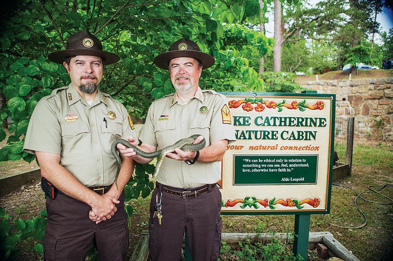 Keith Bell, left, and Steve Donahou, park interpreters at Lake Catherine State Park, show off Elvis the kingsnake.  Elvis is a speckled kingsnake who is used to teach visitors about the differences between venomous and non-venomous snakes in Arkansas.