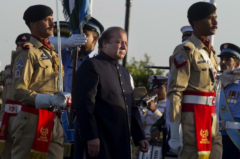 Newly elected Prime Minister of Pakistan Nawaz Sharif, center, reviews guards of honor in Islamabad, Pakistan, Wednesday, June 5, 2013. Sharif took office Wednesday vowing to fix the country's ailing economy and end electricity blackouts while also calling for an end to American drone strikes in the tribal areas. (AP Photo/B.K. Bangash)