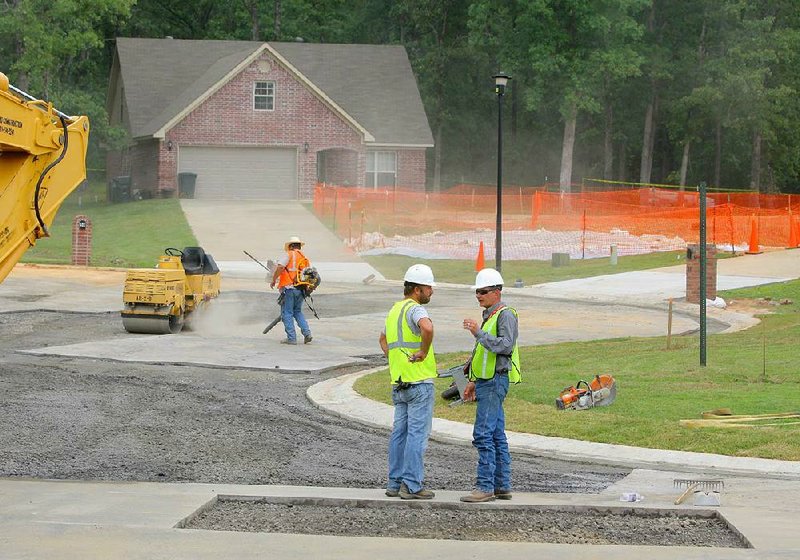 Orange snow fencing, upper right, surround the area where a pipeline rupture occurred as cleanup work continues Wednesday afternoon, June 5, 2013, on North Starlite Road in Mayflower's Northwood subdivision.