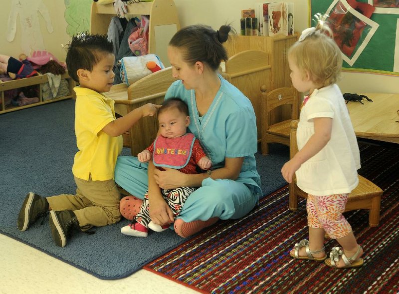 Christie Krumwiede, teacher and caregiver at Emma Early Head Start in Springdale, works with some of the kids Friday morning in Springdale.  Recent cuts in the Head Start Program have been effecting local programs.