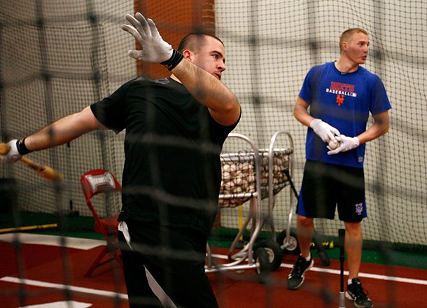 Former Razorback infielder Zack Cox takes batting practice in the batting cages with Brandon Nimmo while training on Wednesday, Jan. 30, 2013, at Baum Stadium in Fayetteville. Cox currently plays in the Miami Marlins organization while Nimmo plays in the New York Mets organization.