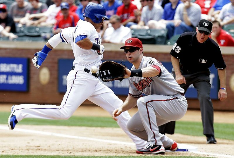 Texas Rangers Leonys Martin (2) jumps back to first base beating the pick off against Arizona Diamondbacks first baseman Paul Goldschmidt during the baseball game Thursday, May 30, 2013, in Arlington, Texas.  Looking on is umpire Lance Barksdale. (AP Photo/LM Otero)