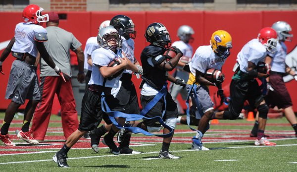 Campers participate in drills Monday during football camp at the University of Arkansas. story.lead_photo.caption
