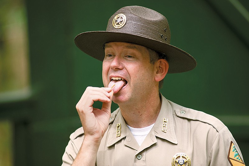 Park interpreter Jason Parrie eats a mealworm during a program about eating insects at DeGray Lake Resort State Park.