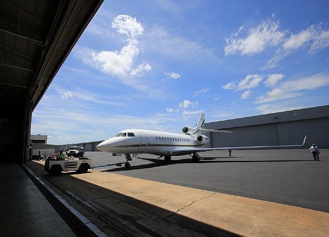 Employees move a Falcon 7X jet into a hangar at the Dassault Falcon completion center in Little Rock. 