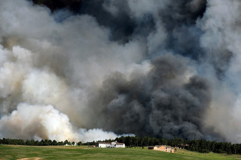 Large plumes of smoke rise from a wild land fire in the Black Forest northeast of Colorado Springs, Colo. on Tuesday, June 11, 2013. Homes have already burned and the wind is expected to continue through the afternoon. 