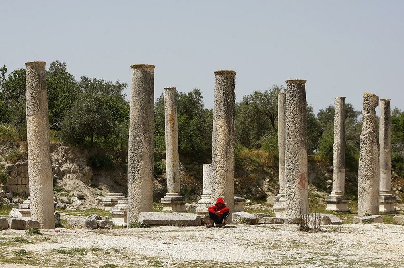 A Palestinian boy sits near the Roman basilica and forum in the village of Sebastia. The archaeological sites of the ancient town have attracted tourists and pilgrims over the centuries but today are in a state of neglect. 