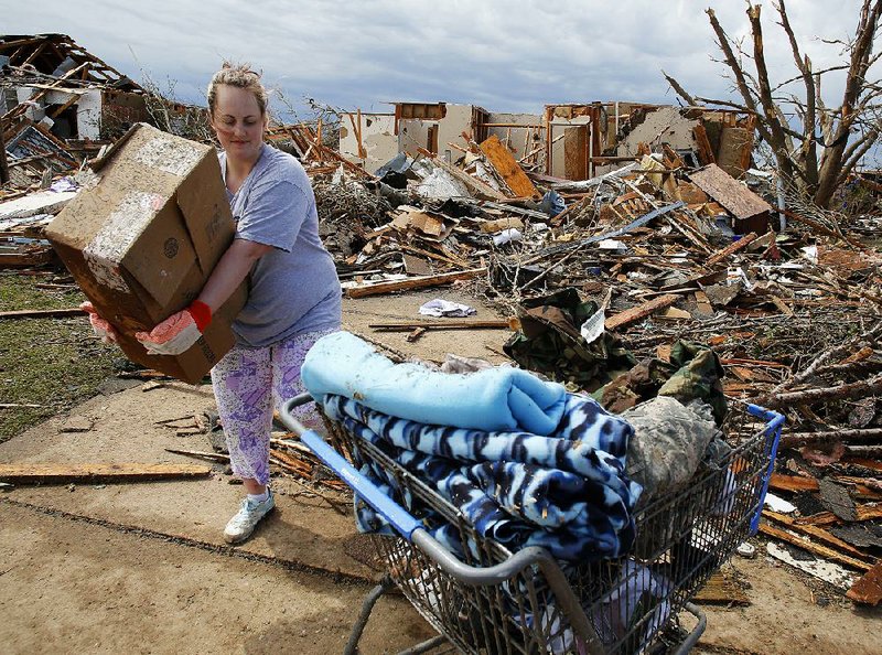 Kandi Scott of Moore, Okla., collects items from her home the day after an EF5 tornado hit the town in May. Members of the Dwelling Place church in Fayetteville were in Moore that day to help residents. 