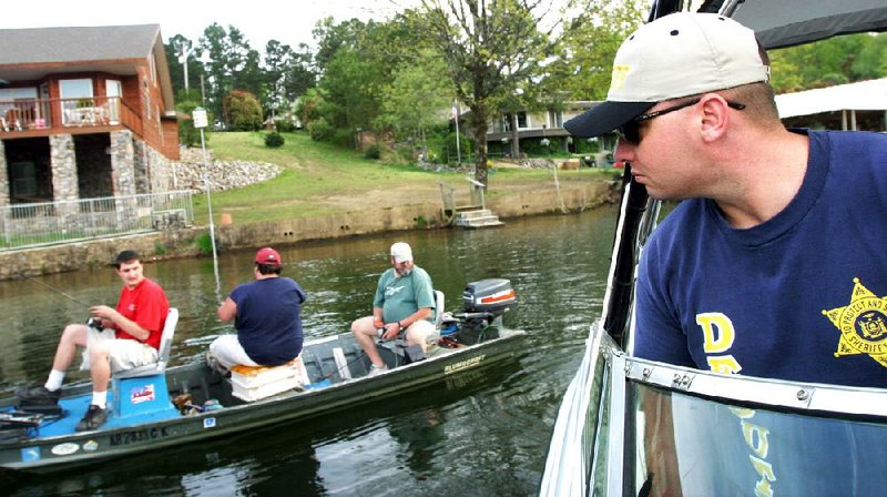 Neil Parliment, a marine patrol officer with the Garland County sheriff’s office, checks on fishermen and other boaters on Lake Hamilton in this photo taken in 2003. Parliment was arrested Thursday on a federal warrant accusing him of arranging for a prostitute to travel from Memphis to Hot Springs. 