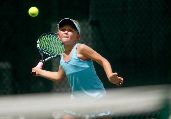 Caroline Long, 10, of Rogers returns a shot on while playing Sarah Schneringer, 11, of Fayetteville during their match Friday at the Colgate Junior Tennis Open Championships at Pinnacle Country Club in Rogers. 