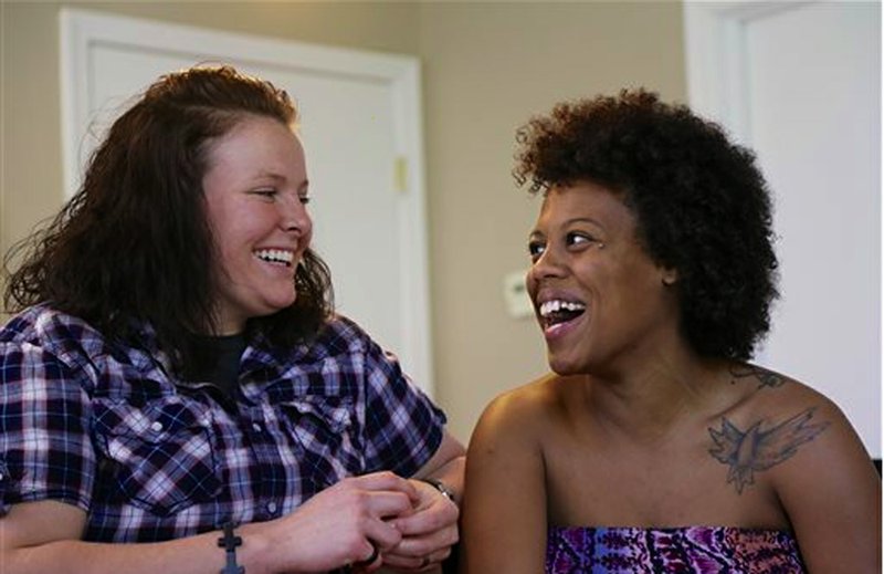 Danielle Powell, right, and her spouse Michelle Rogers are photographed in Omaha, Neb., Wednesday, June 12, 2013. Grace University, a Christian college in Omaha, has revoked Powell's scholarship and expelled her because she was public about a same-sex relationship. The college also is demanding payment of tuition and won't send her transcripts to other schools until she pays off her bill.