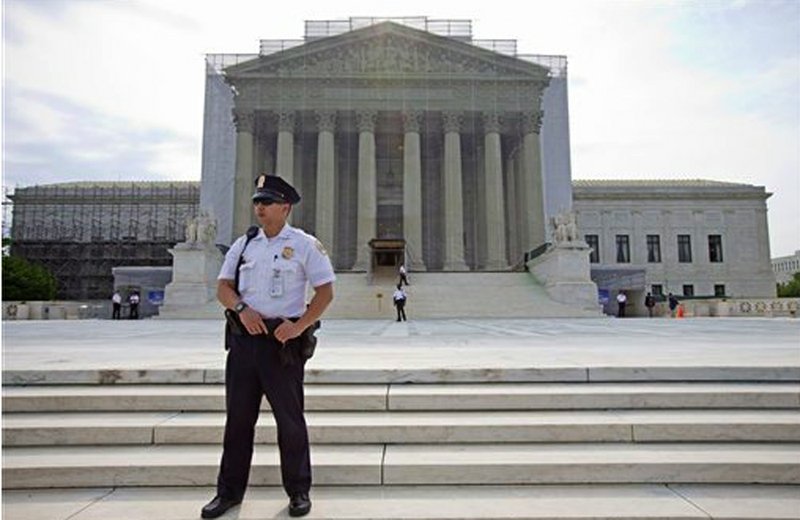 A police officer keeps watch outside the Supreme Court in Washington, Monday, June 17, 2013. With a week remaining in the current Supreme Court term, several major cases are still outstanding that could have widespread political impact on same-sex marriage, voting rights and affirmative action.