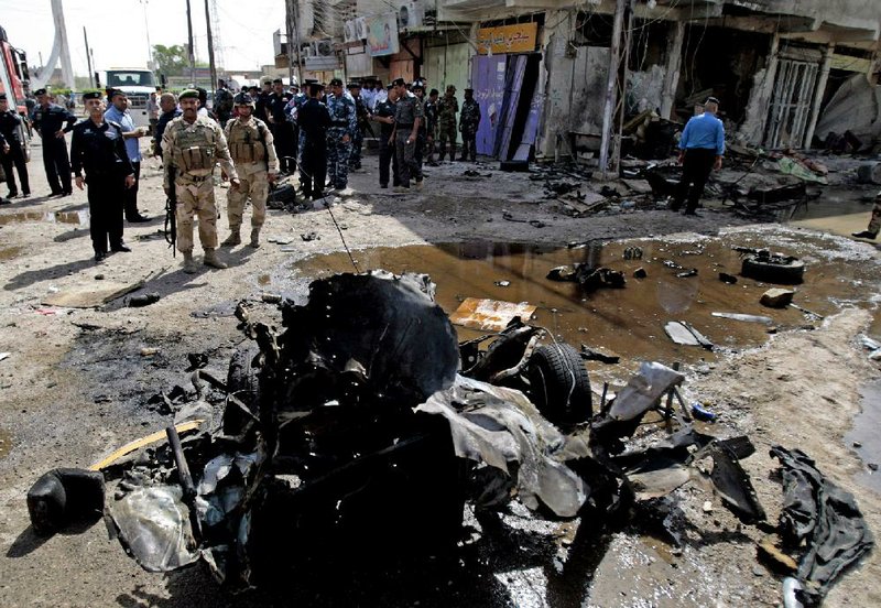 Iraqi security forces inspect the site of a car-bomb attack in Basra, 340 miles southeast of Baghdad on Sunday. Blasts hit half a dozen cities and towns Sunday in Iraq, killing at least 51 people. 