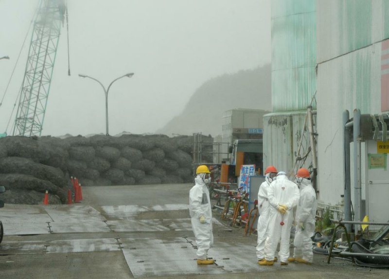 Workers take a break earlier this month outside the Fukushima Daiichi nuclear power plant in Japan. Reactors at the plant were damaged by an earthquake and tsunami in 2011. 