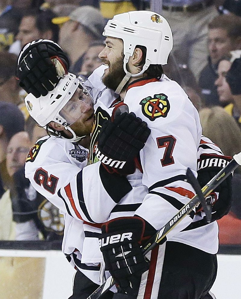 Chicago defenseman Brent Seabrook (7) celebrates his game-winning goal against Boston with Duncan Keith (2) during the first overtime period in Game 4 of the NHL Stanley Cup finals Wednesday in Boston. The goal gave the Blackhawks a 6-5 victory and evened the best-of-7 series at 2-2. 