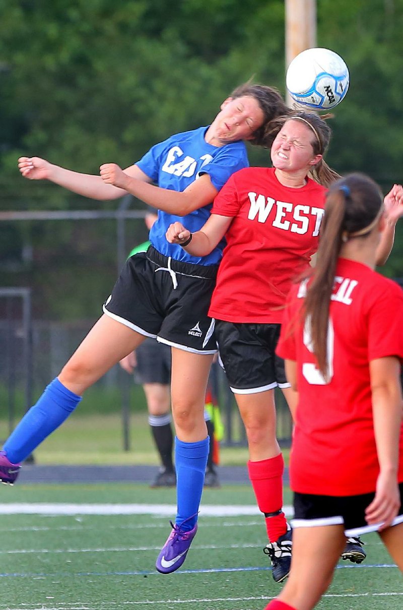 North Little Rock’s Katie Van Pelt (left) of the East and Siloam Springs’ Annabeth Raiford of the West battle for a header during Wednesday night’s girls All-Star soccer game in Conway. 