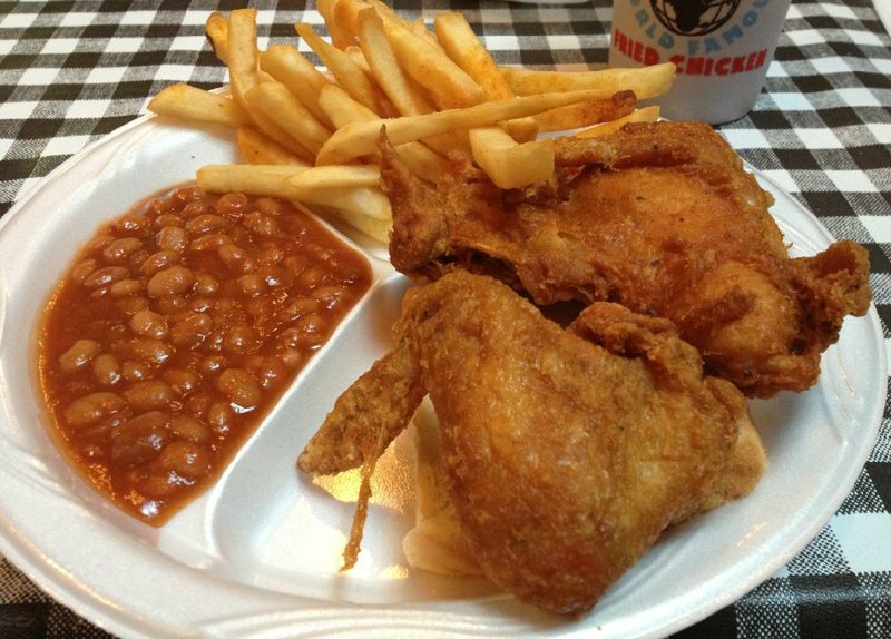A 2 Piece White Plate with seasoned fries and baked beans at Gus’s World Famous Fried Chicken. 