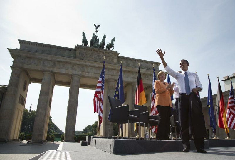 President Barack Obama waves to the crowd Wednesday at Berlin’s Brandenburg Gate as he arrives with German Chancellor Angela Merkel. In a wide-ranging speech nearly 50 years after John F. Kennedy’s famous Cold War speech at the gate in the once-divided city, Obama renewed his call for reducing nuclear stockpiles and confronting climate change, which he called “the global threat of our time.”