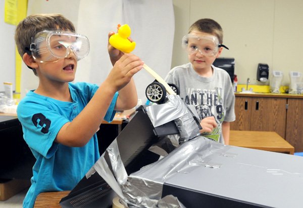 Nathan Kesner, 8, left, and Tyler Moore, 8, prepare to launch a rubber duck Wednesday during Camp Invention at Bonnie Grimes Elementary School in Rogers. The goal for the group was to build a launcher to toss the ducks back to their homes. 