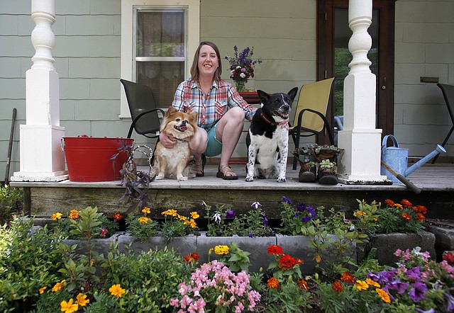 Alyssa Snyder sits with the dogs on her favorite personal space, the front porch of her Fayetteville home Wednesday afternoon.