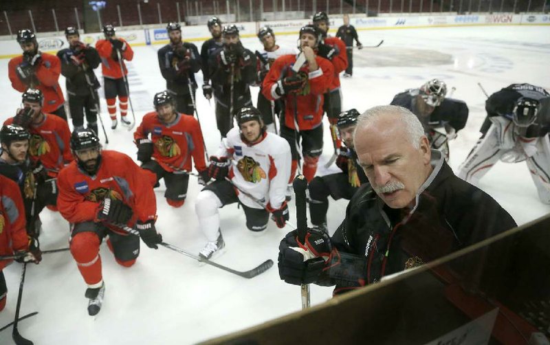 Chicago Blackhawks head coach Joel Quenneville, right, diagrams a drill during an NHL hockey practice Friday, June 21, 2013 in Chicago. The Blackhawks will host the Boston Bruins in Game 5 of the Stanley Cup Final series Saturday. (AP Photo/Charles Rex Arbogast)