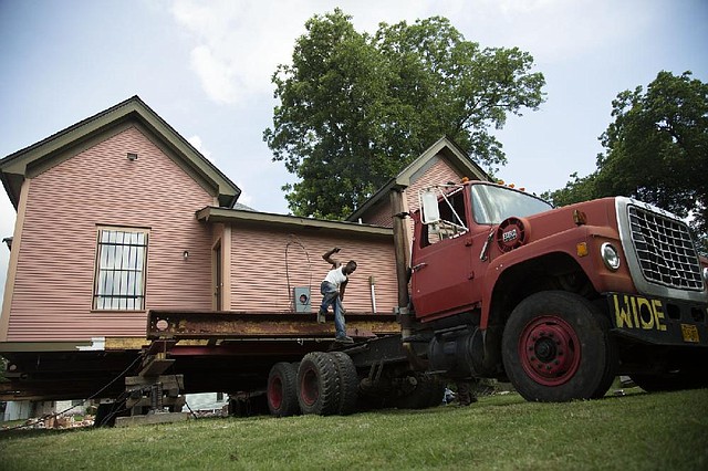 Arkansas Democrat Gazette/MELISSA SUE GERRITS 06/19/13- Virgil Doss with Epperson Blaineco Structural Movers hops down from the bed of a truck as a historic home is prepared to be moved to another lot Tuesday, June 18, 2013. Charles Ray with the Cooperative Baptist Fellowship of Arkansas works with the Arkansas Baptist College to restore buildings purchased through the school as they work closely with the community in a revitalization process. 