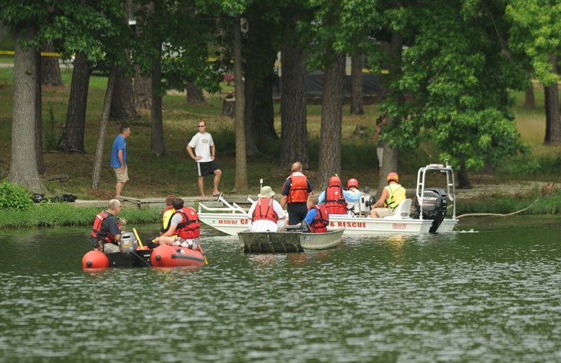 Emergency personnel search near the shore of Lake Wedington from aboard rescue boats for a swimmer Saturday, June 22, 2013, after a man was reported missing while swimming.