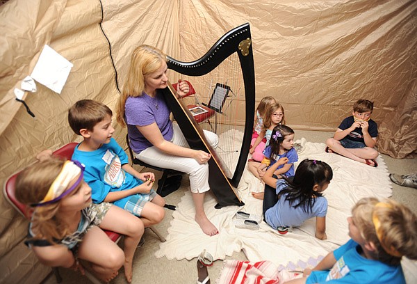 Beth Stockdell, center, shares her music with children June 12 during Vacation Bible School at First United Presbyterian Church in Fayetteville. The theme was “Paul’s Dangerous Journey to Tell the Truth,” and organizers tried to give the children the flavor of the Greek culture. Stockdell is a member of the church. 
