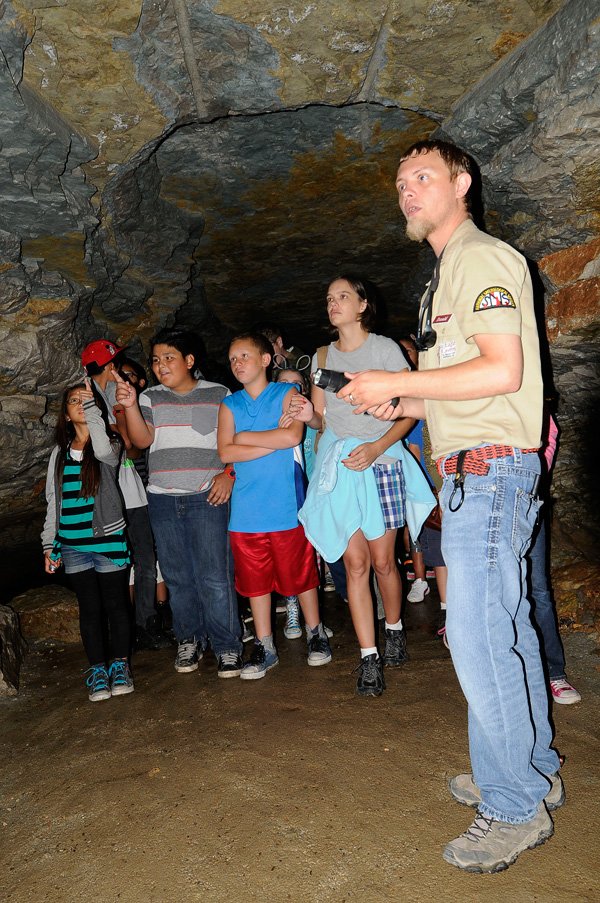 Donald Locander (right), a guide at War Eagle Cavern, leads a cave tour Friday for students from the Decatur School District. The students, ranging from elementary school to high school age, were participating in a new summer learning program offered by the district.