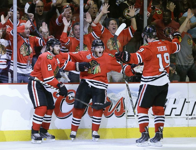 Chicago Blackhawks defenseman Patrick Kane (center) is congratulated by teammates Duncan Keith (left) and Jonathan Toews after scoring his second goal in Saturday night’s 3-1 victory over the Boston Bruins in Game 5 of the Stanley Cup finals. 