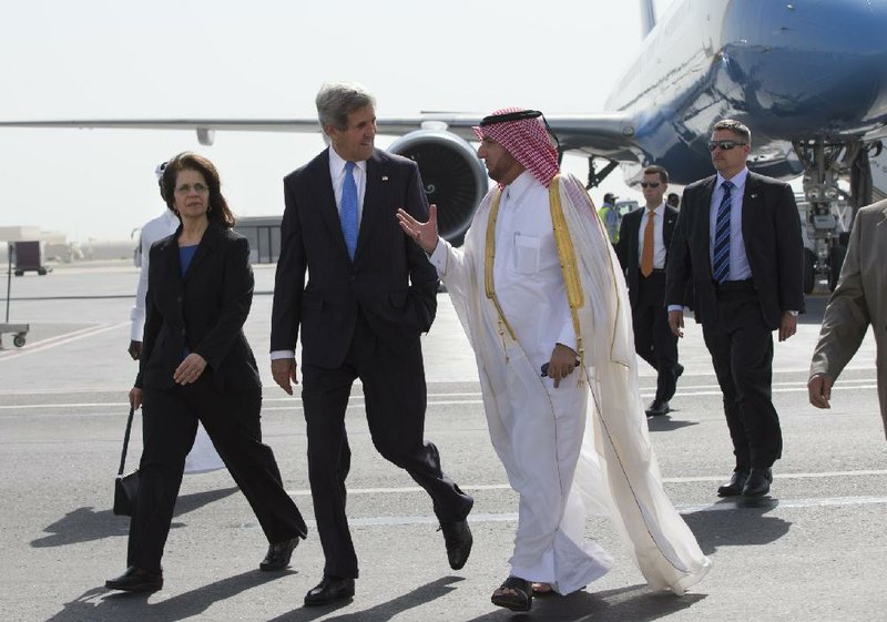 Secretary of State John Kerry, with U.S. envoy to Qatar Susan Ziadeh, is greeted by a Qatari official as he arrives Saturday in Doha. 