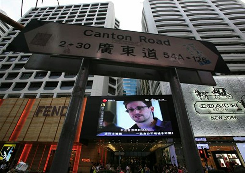 A TV screen shows a news report of Edward Snowden, a former CIA employee who leaked top-secret documents about sweeping U.S. surveillance programs, at a shopping mall in Hong Kong Sunday, June 23, 2013. The former National Security Agency contractor wanted by the United States for revealing two highly classified surveillance programs has been allowed to leave for a "third country" because a U.S. extradition request did not fully comply with Hong Kong law, the territory's government said Sunday.